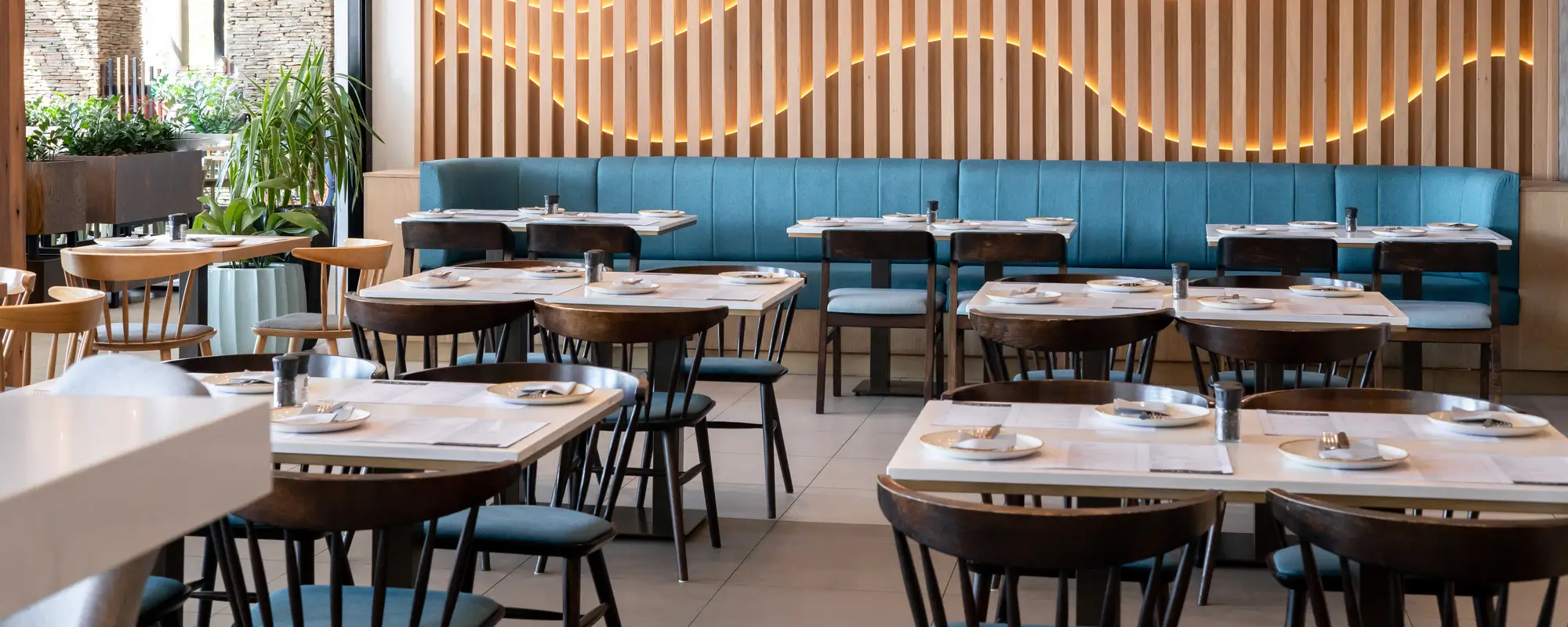 Modern commercial restaurant interior with dining tables, chairs, and blue booths by Liangjiu Furniture