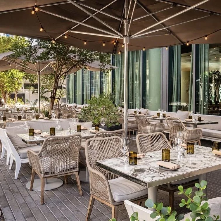 Patio dining tables and chairs under an umbrella canopy