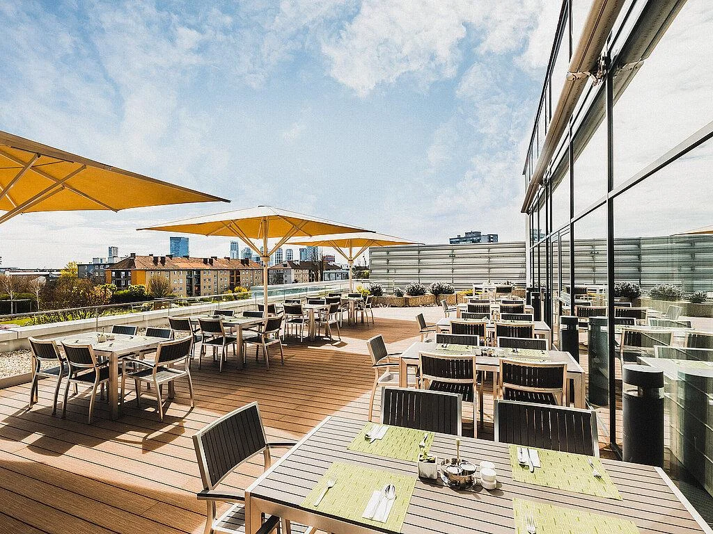 Outdoor dining tables and chairs on a terrace with shade umbrellas