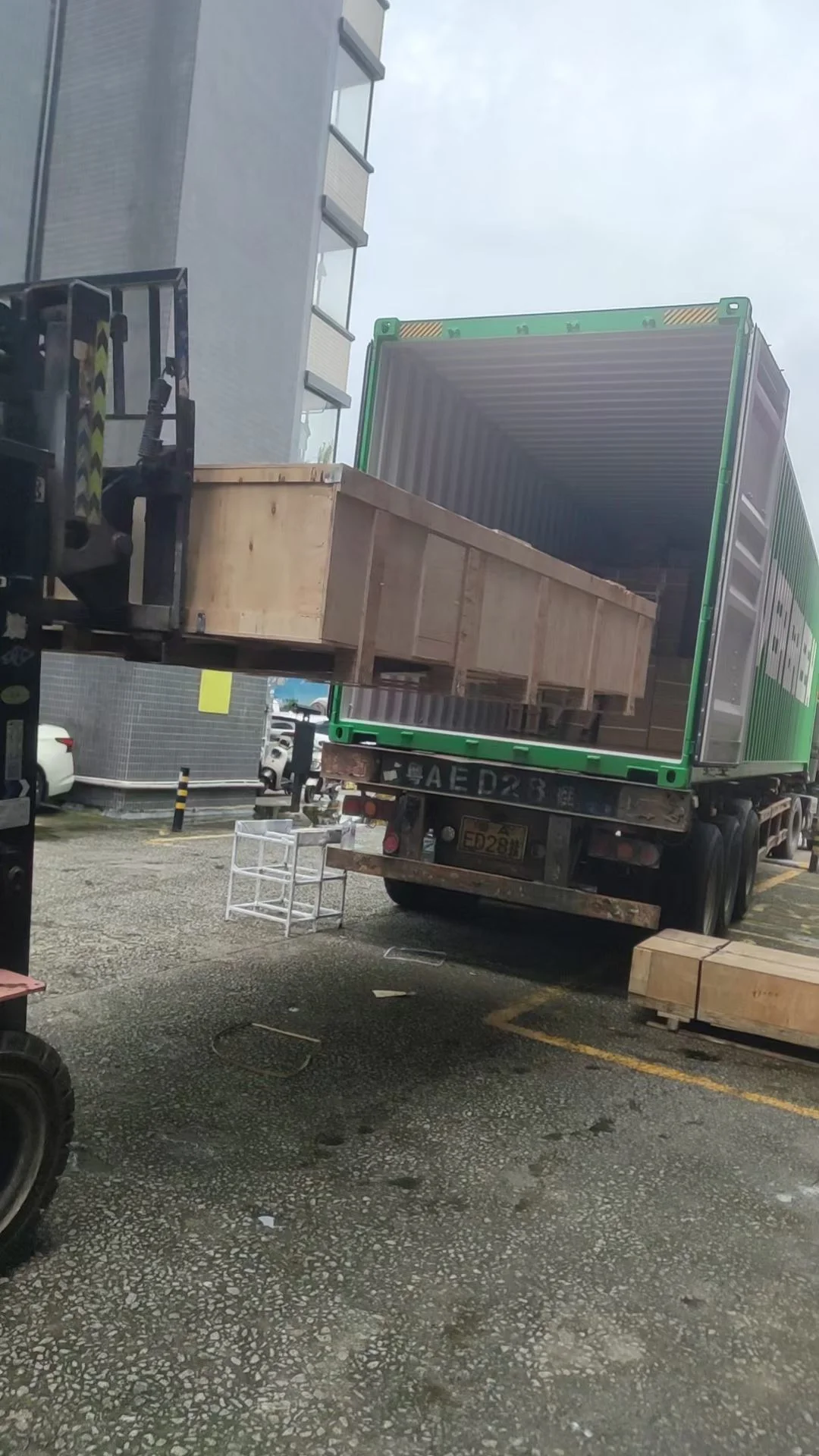 Forklift moving a wooden shipping crate into a container