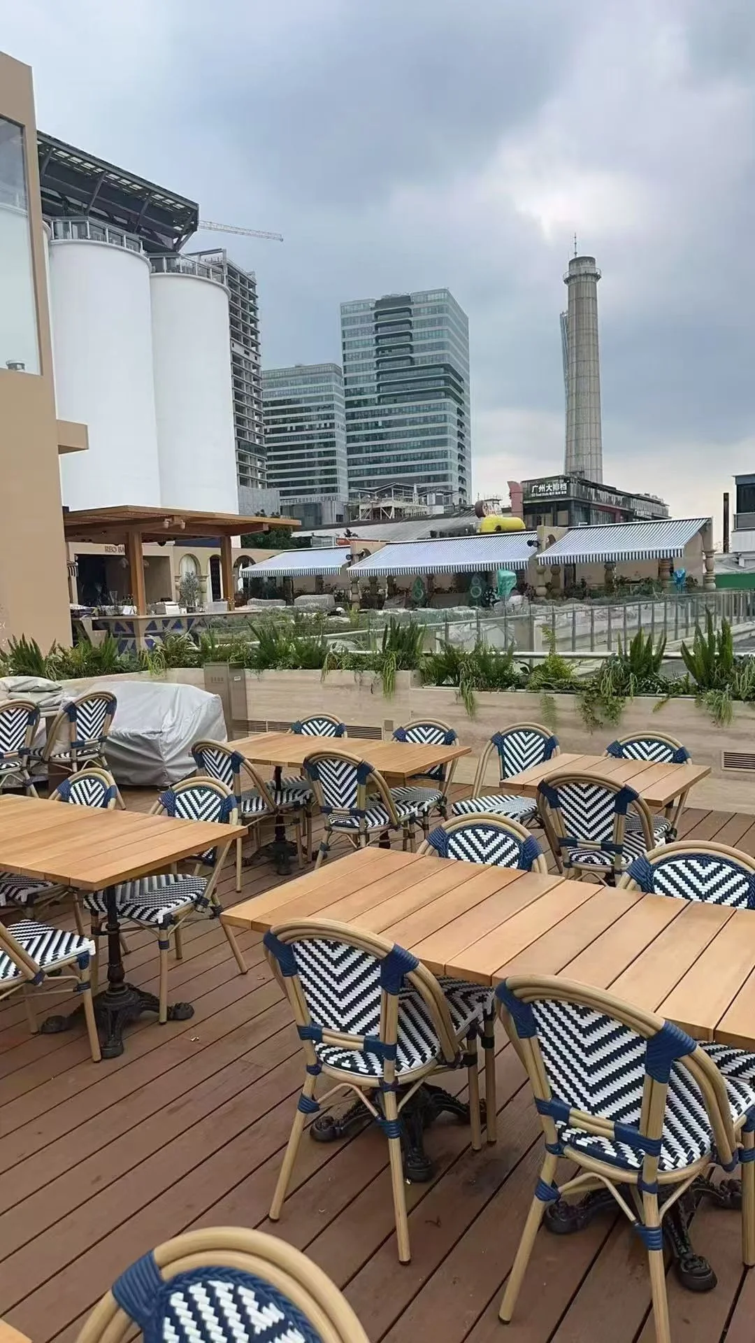 Outdoor restaurant tables with blue and white woven chairs