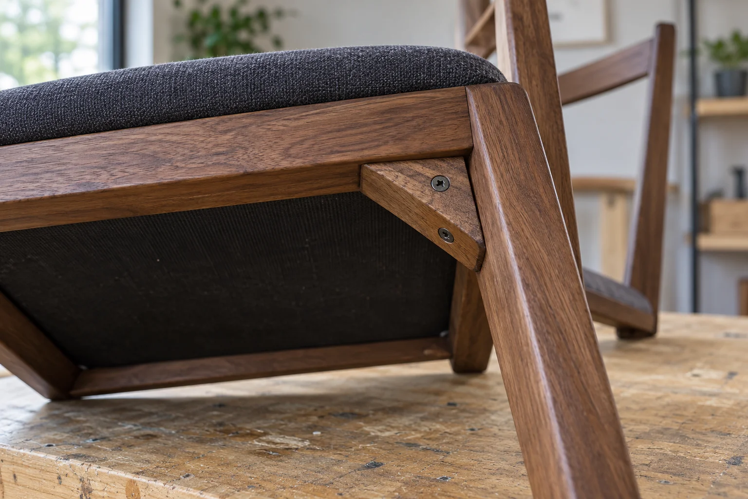 Close view of the underside of a wooden dining chair showing seat supports and frame connections