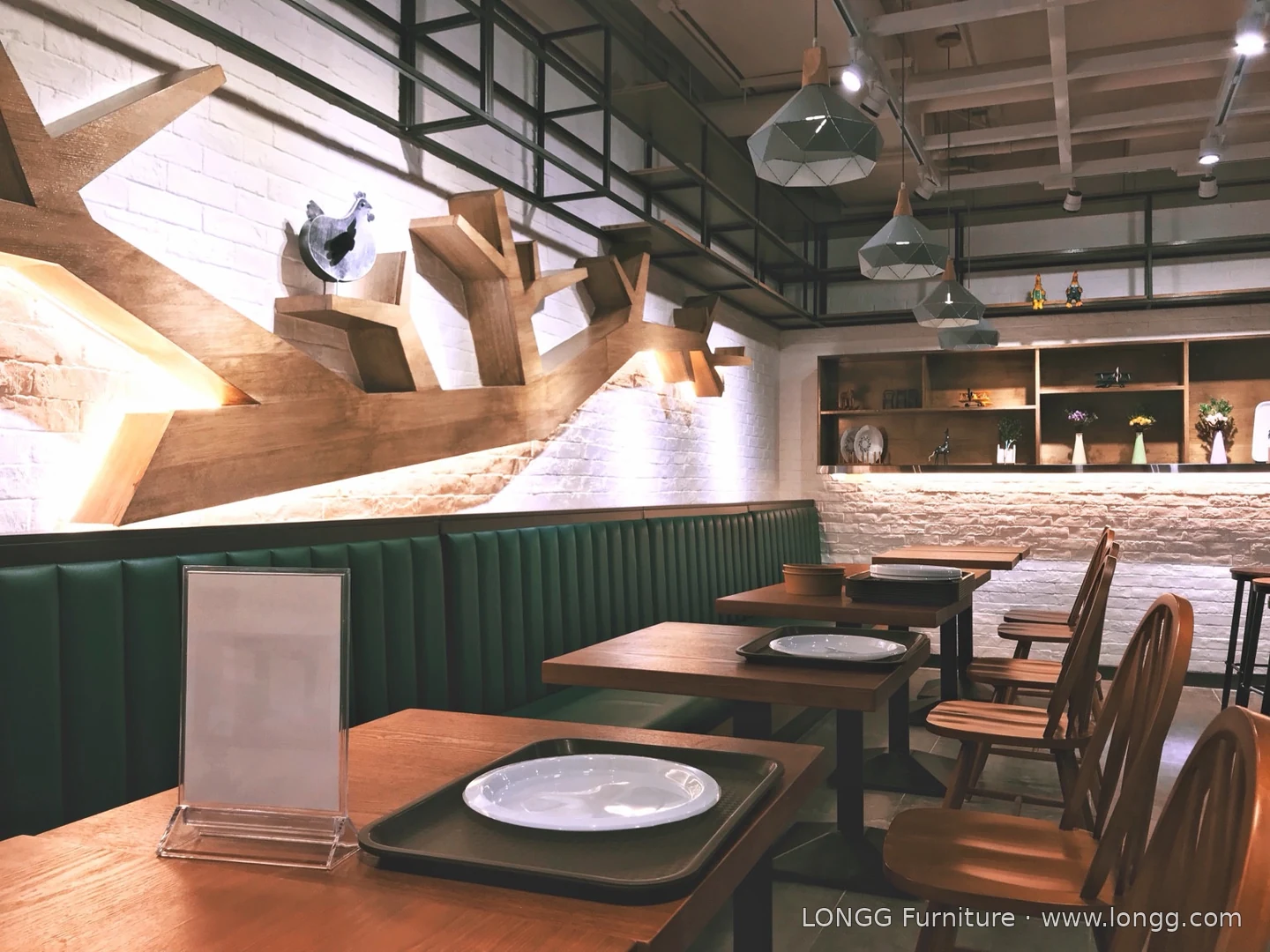 Wood-tone dining tables and chairs beside green upholstered banquette seating